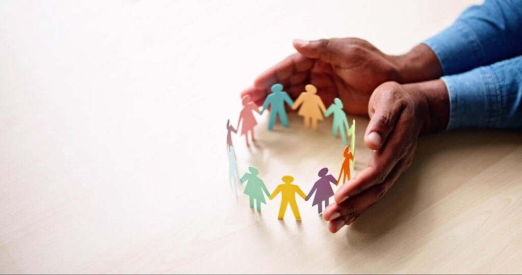 The image of the hands surrounding paper people represent how there are ways to try to protect your family’s finances from built in inflation.