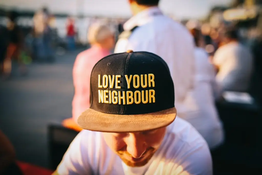 Man in baseball cap with the words "love your neighbor" representing the importance of you and your investment consultant having shared values