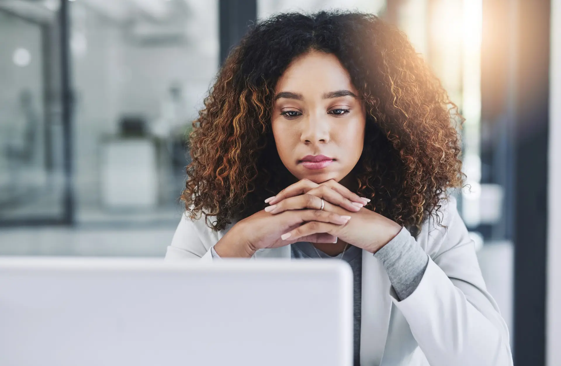 A woman is deep in thought, representing the need to consider the downsides to IRAs.
