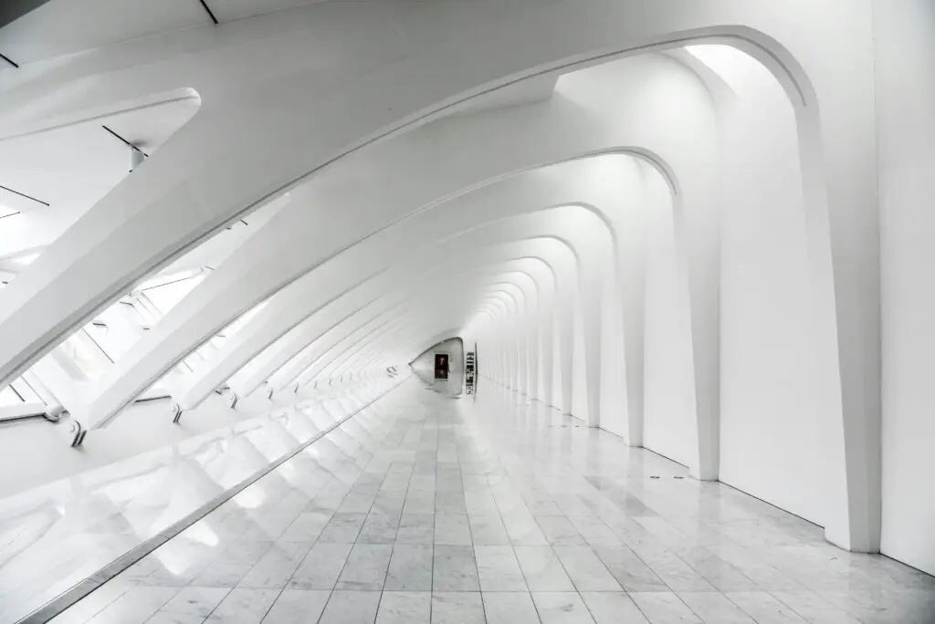 Long white corridor with interesting arches and a door at the end to indicate the idea of future planning in annual financial reviews.