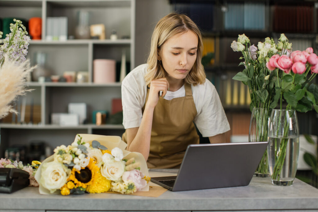 Florist looking at her laptop and wondering what the best retirement plans for self employed individuals might be