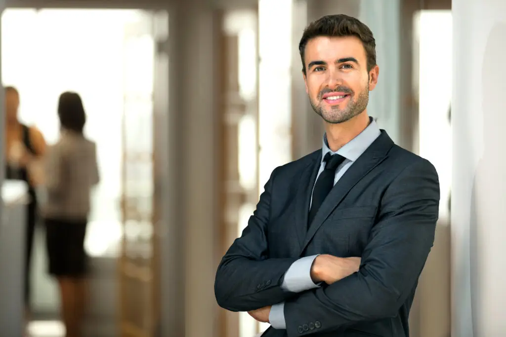 Male model in suit with arms crossed, looking competent and assured, to represent a client looking for dedicated financial planning for attorneys like himself