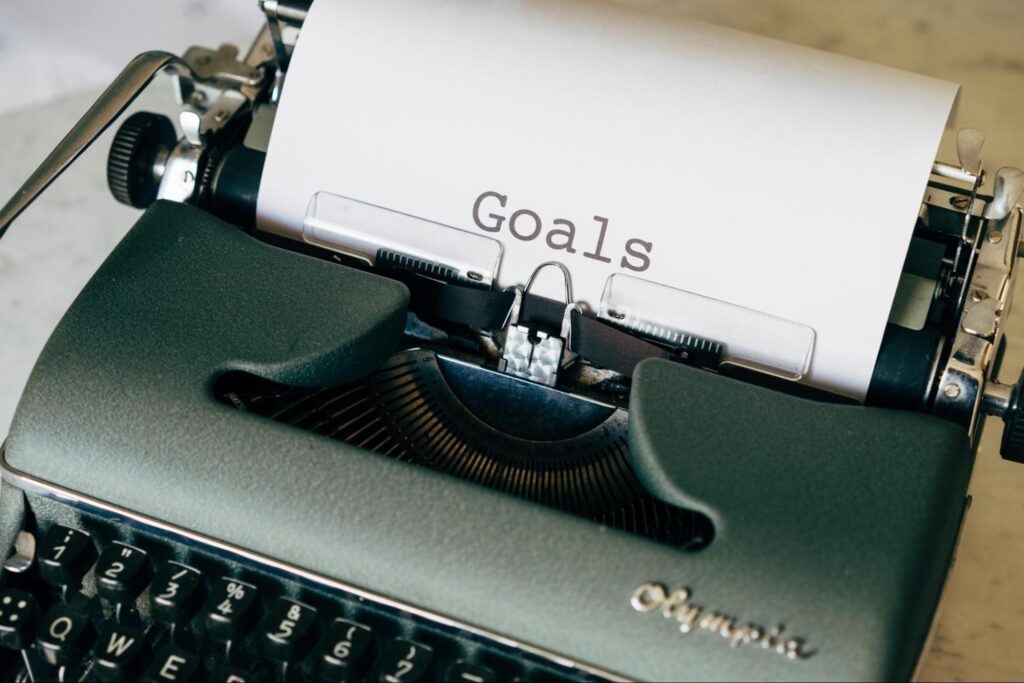 Typewriter with “goals” typed on a sheet of paper, representing the need to set clear goals.