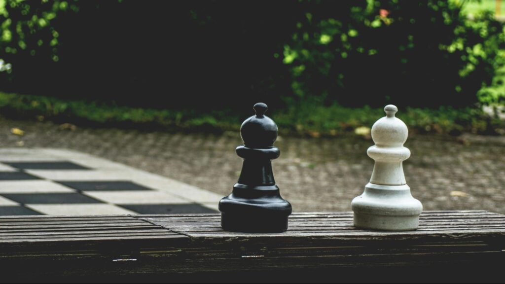 he black and white pawns represent the differences of short-term vs. long-term health insurance options.