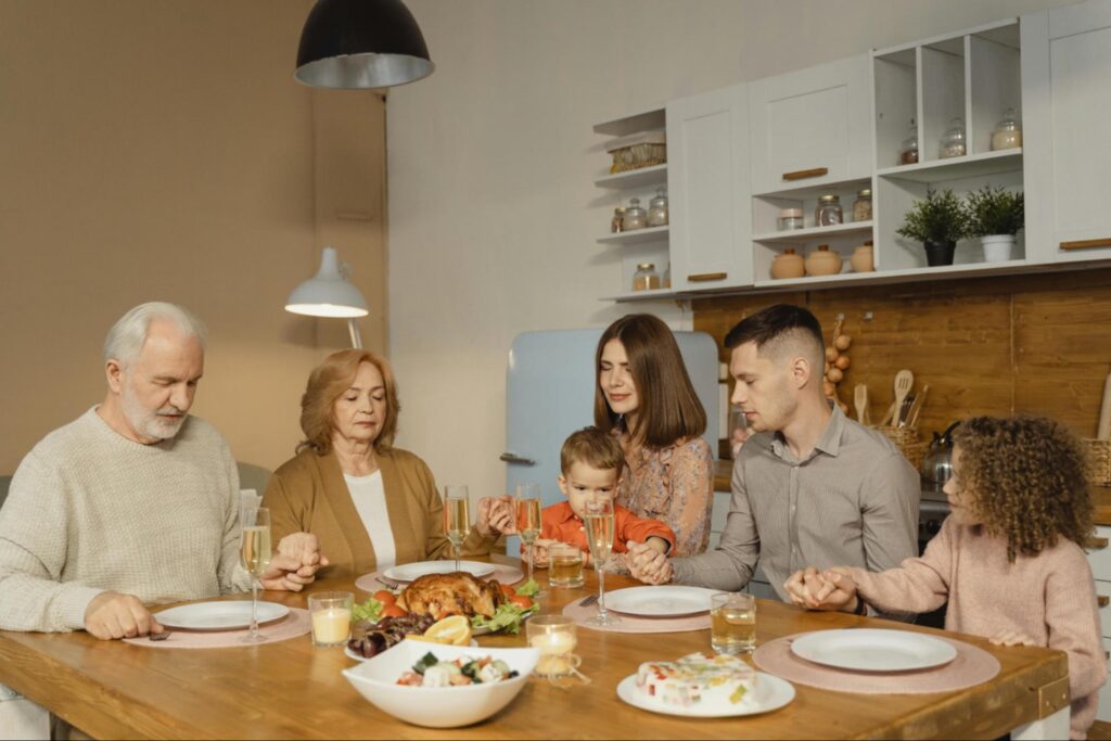 A multi-generational family sitting at a dinner table, illustrating why you might need an estate plan.