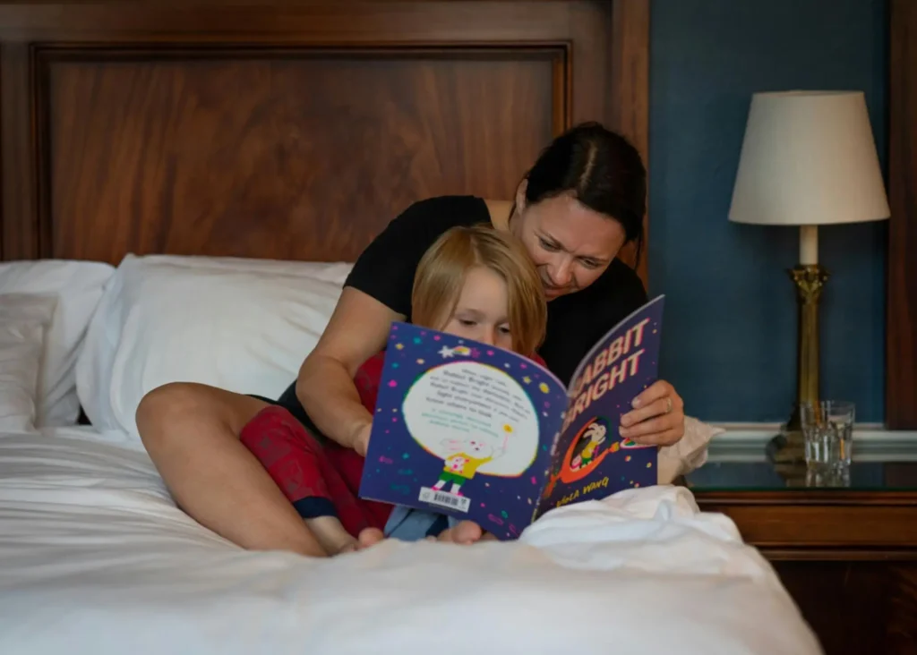 An aunt is excited about the potential tax benefits of contributing to a 529 plan as she invests in her sweet nephew by reading to him.