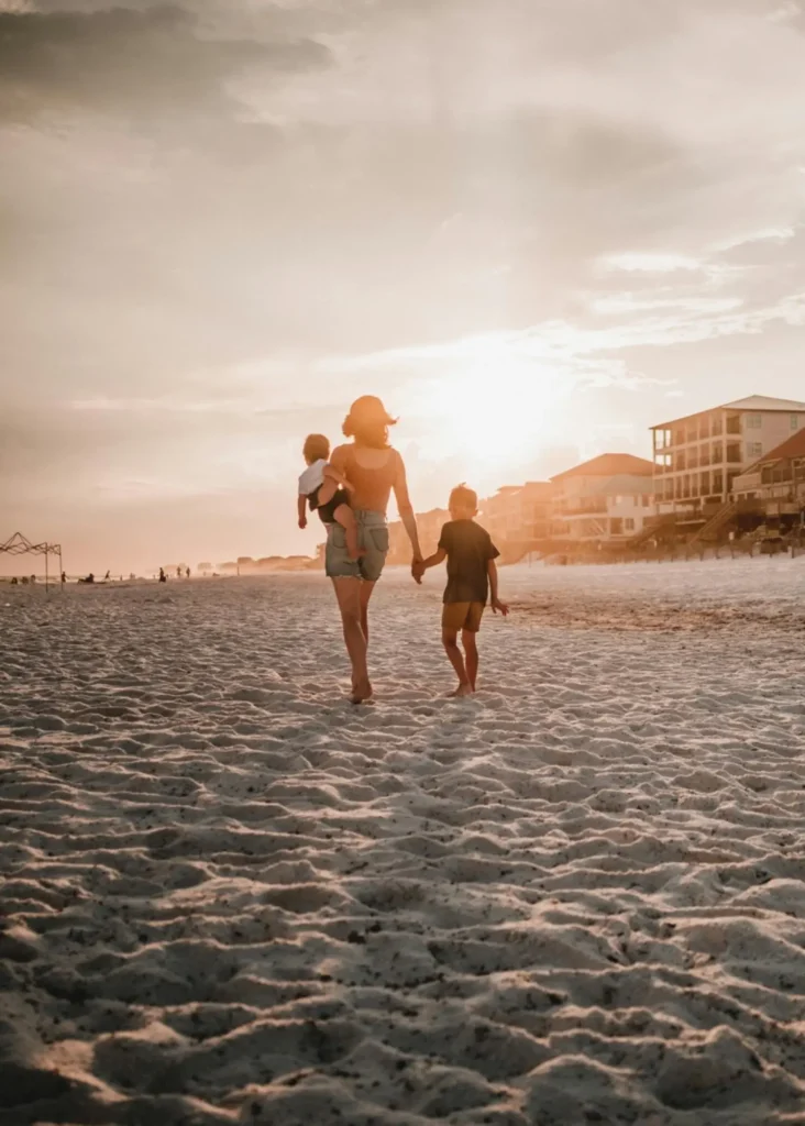 A mother walks on the beach, thinking about the tax benefits of 529 plans for herself that could ultimately help to empower her little family.