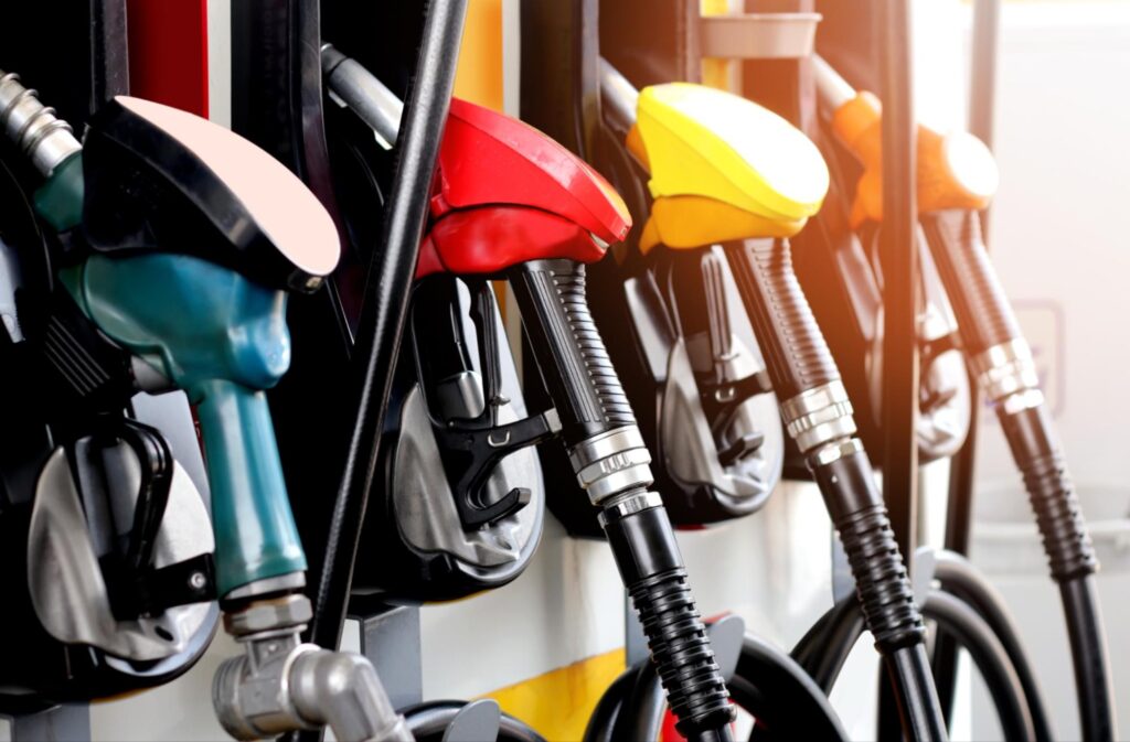 Multicolored fuel pumps representing increased gas prices caused by inflation from tariffs.