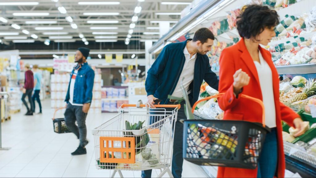 People shopping in a supermarket seeing the cost of inflation from tariffs on their receipt.