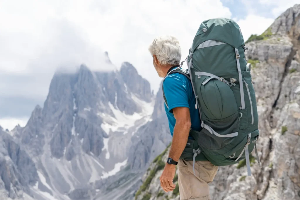 A retired pilot hiking through dramatic mountain scenery, embodying the clarity and new purpose that intentional financial planning for airline pilots can help create.